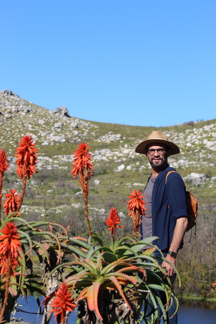 Mikhail Schrader, founder of Travel African Time, among flowering Cape fynbos